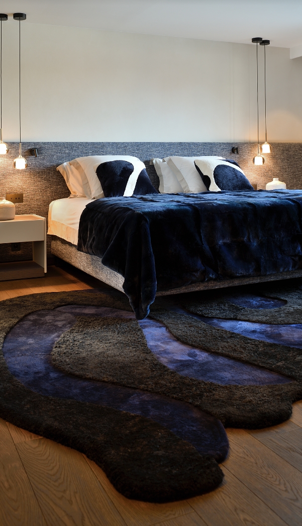 Luxury bedroom with a large dark organic rug