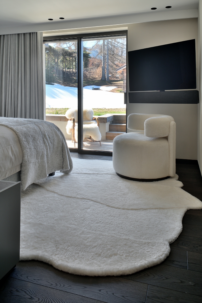 Minimalist bedroom with a view of the slopes and an irregular white rug