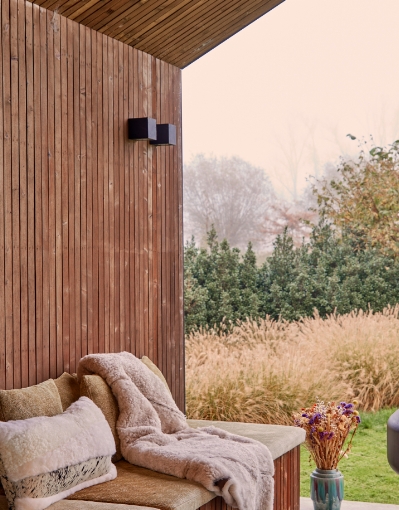 Outdoor relaxation area on a wooden terrace with throws