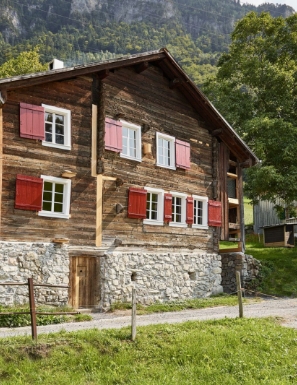 Vue extérieure d'un chalet montagnard traditionnel en vieux bois sous le soleil