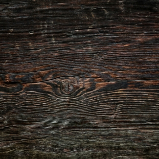 Détail et gros plan sur une texture de bois brûlé ou vieilli noir profond