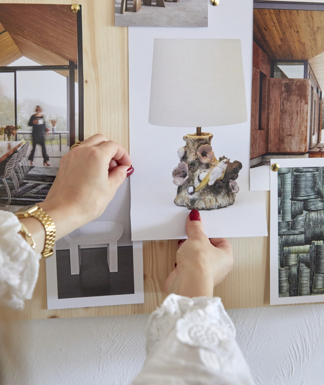 Hands pinning a lamp sketch on a decoration moodboard