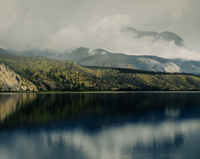 Paysage de montagnes rocheuses et lac réfléchissant sous un ciel nuageux
