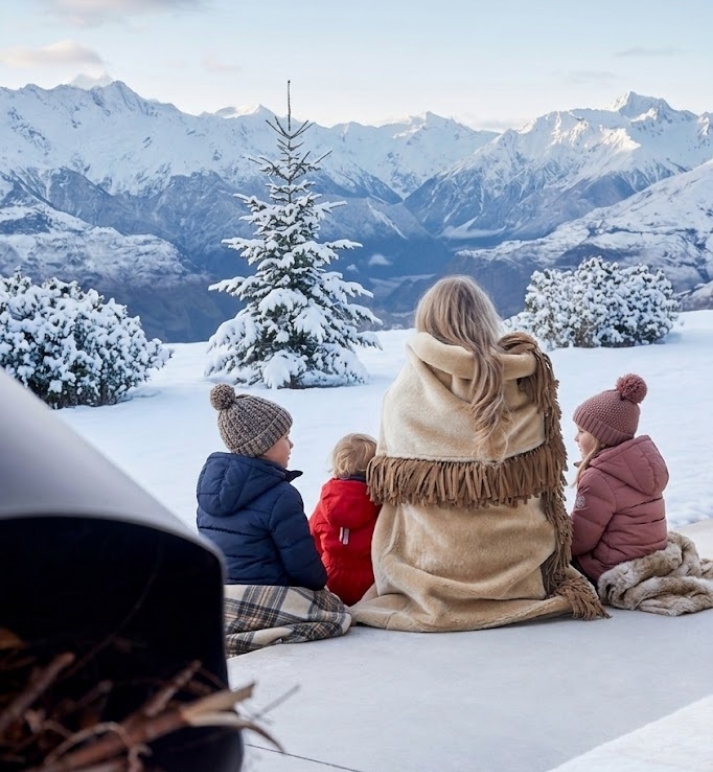 Snowy landscape with modern Norki fur throw and children