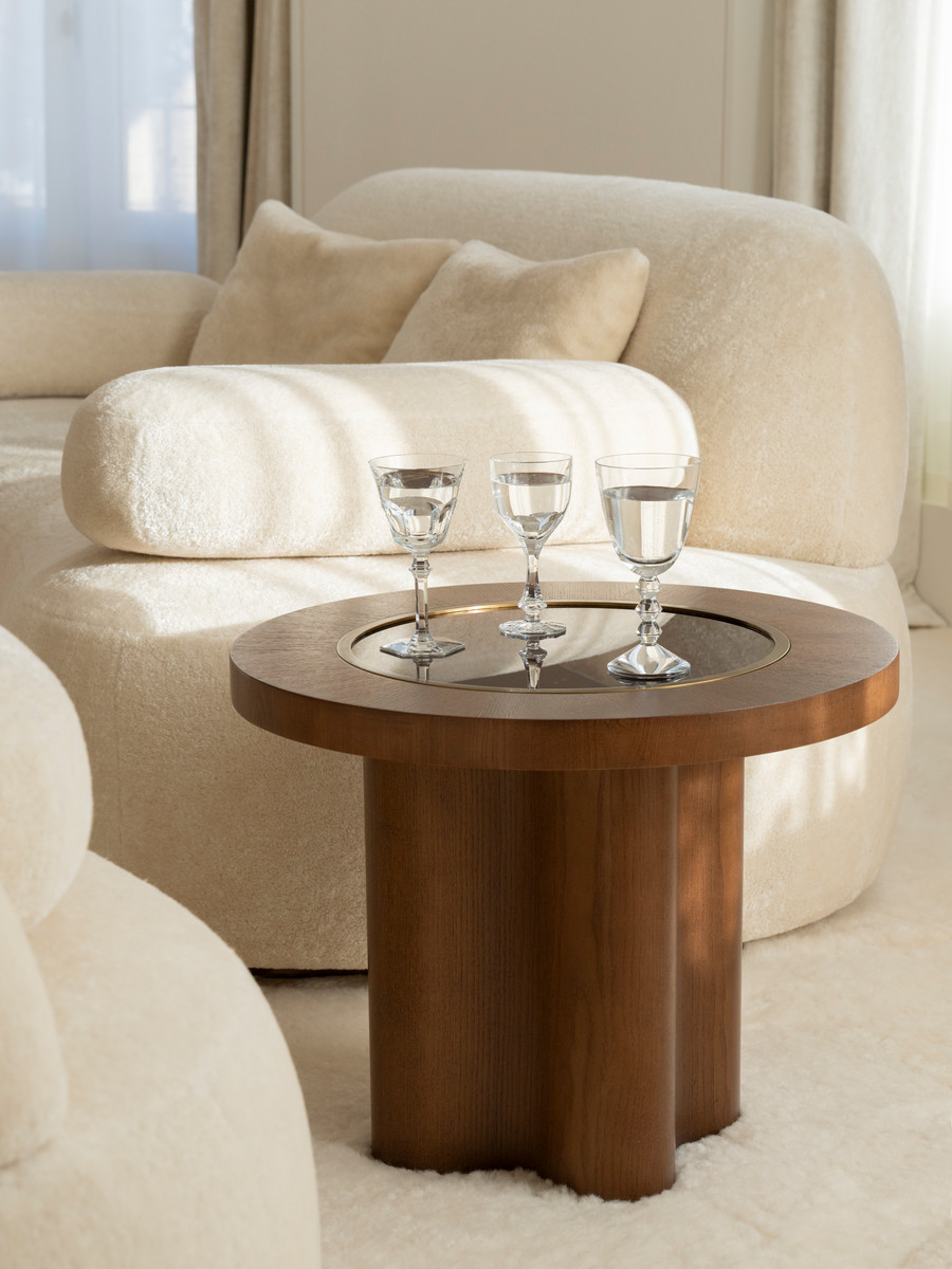 Détail du salon de l'appartement Haussmannien avec canapé organique et table basse en bois posés sur le tapis mur-à-mur sur-mesure