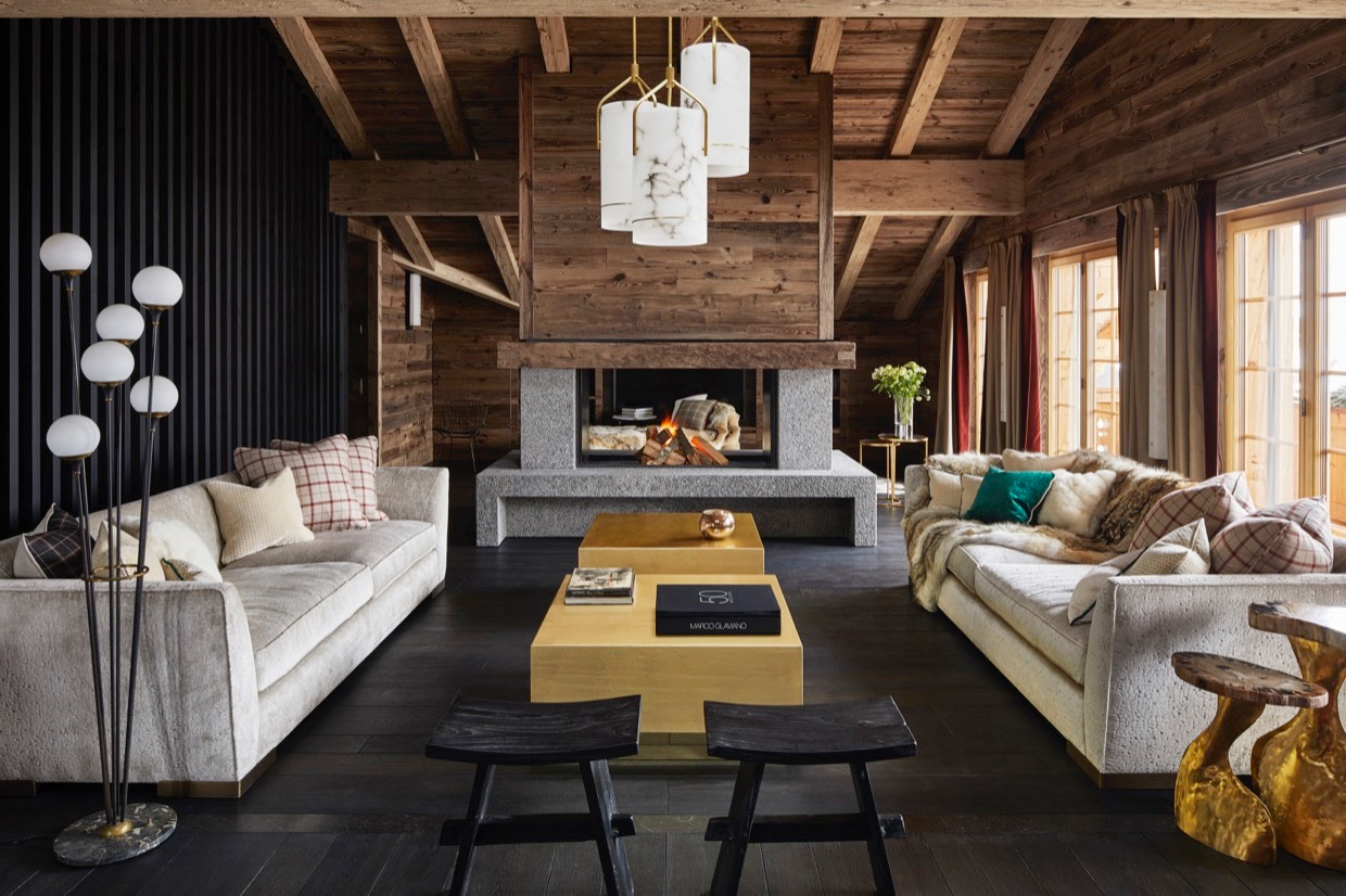Salon de chalet de luxe à Gstaad avec plaids en fourrure naturelle et coussins confectionnés sur-mesure par la Maison Norki